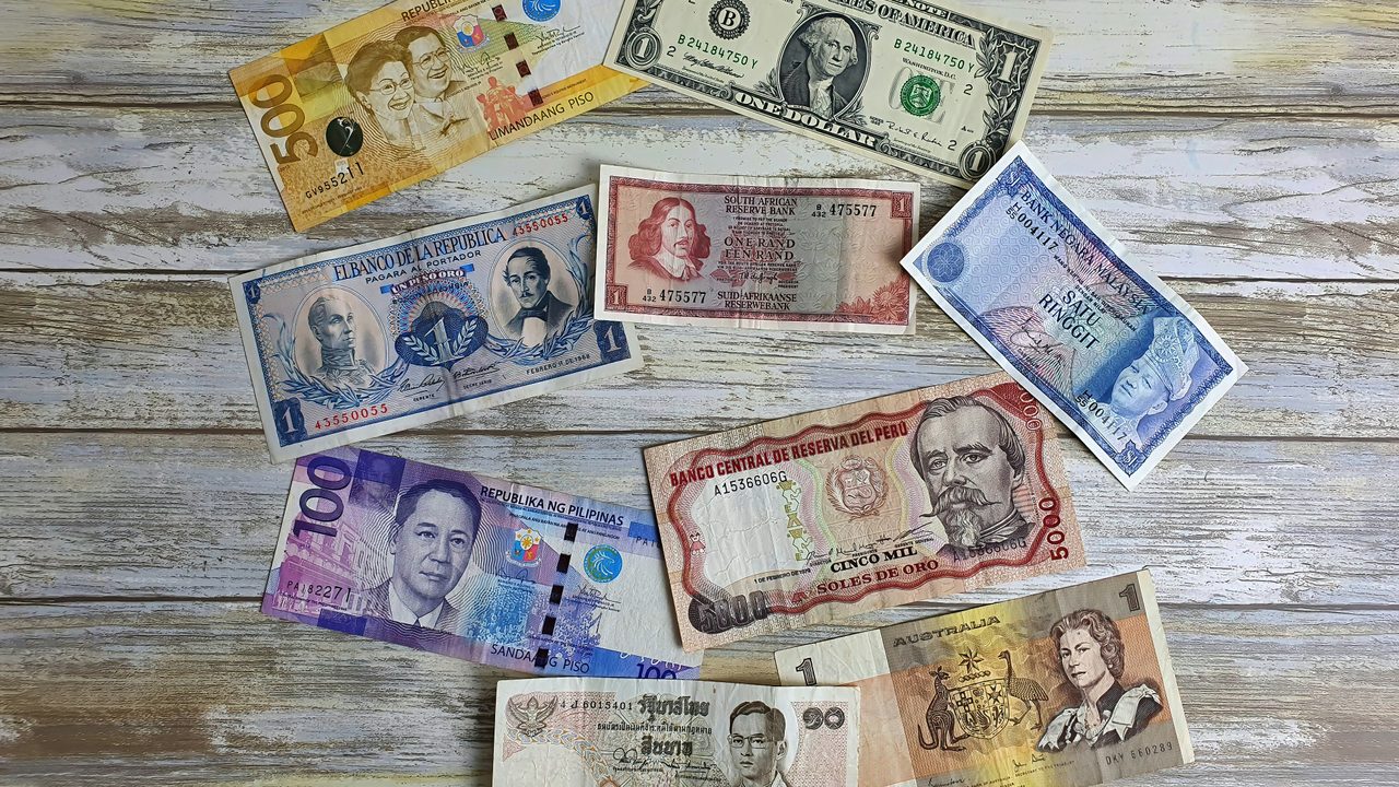 Several bills of various different currencies on a table