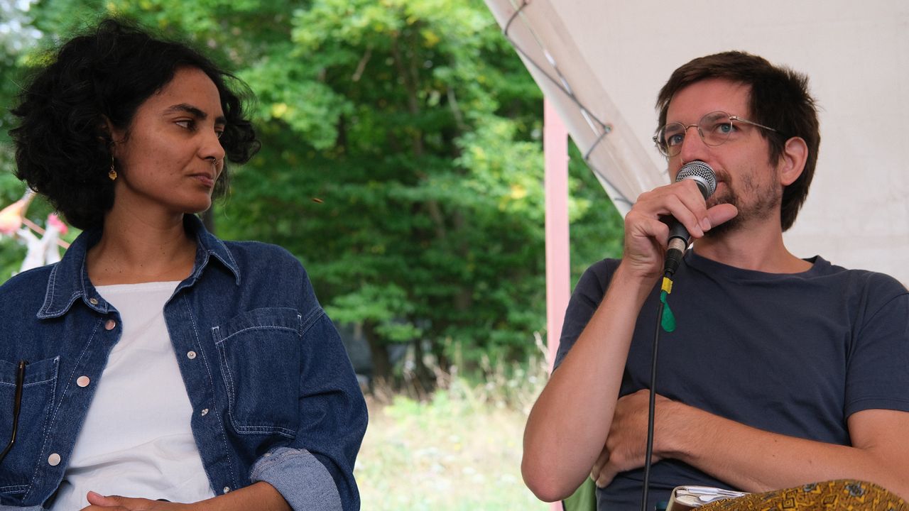 People sitting on a stage talking at a roundtable