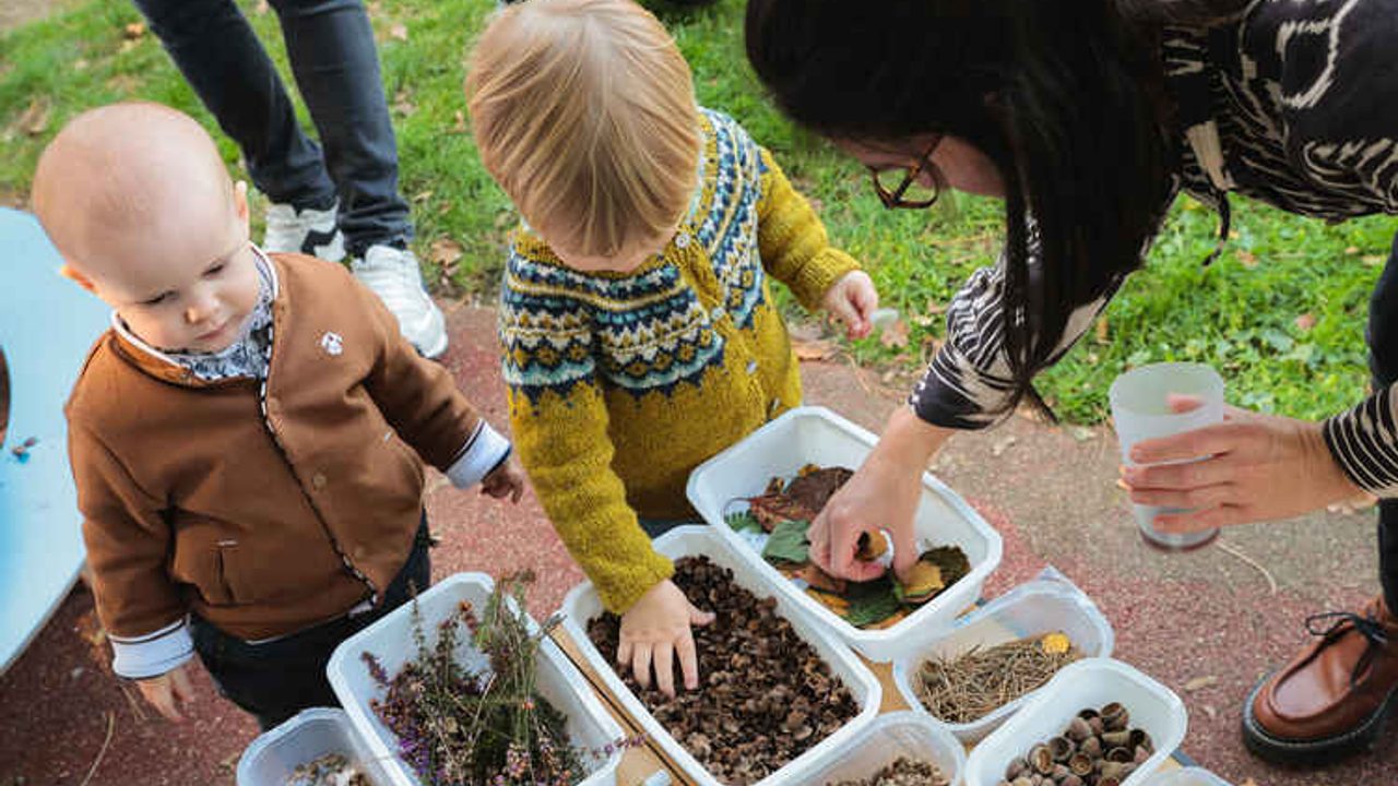 Deux jeunes enfants manipulent des graines, feuilles, herbes, noix.