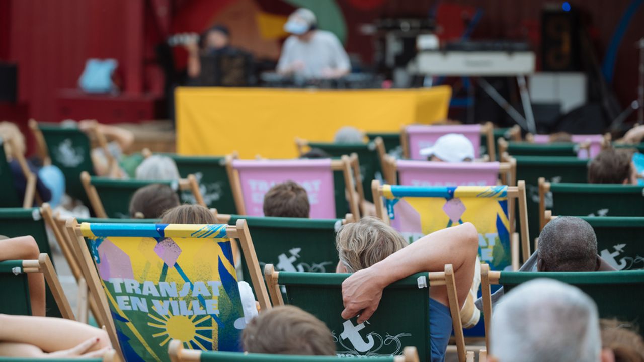 Public assis sur les transats devant un Dj