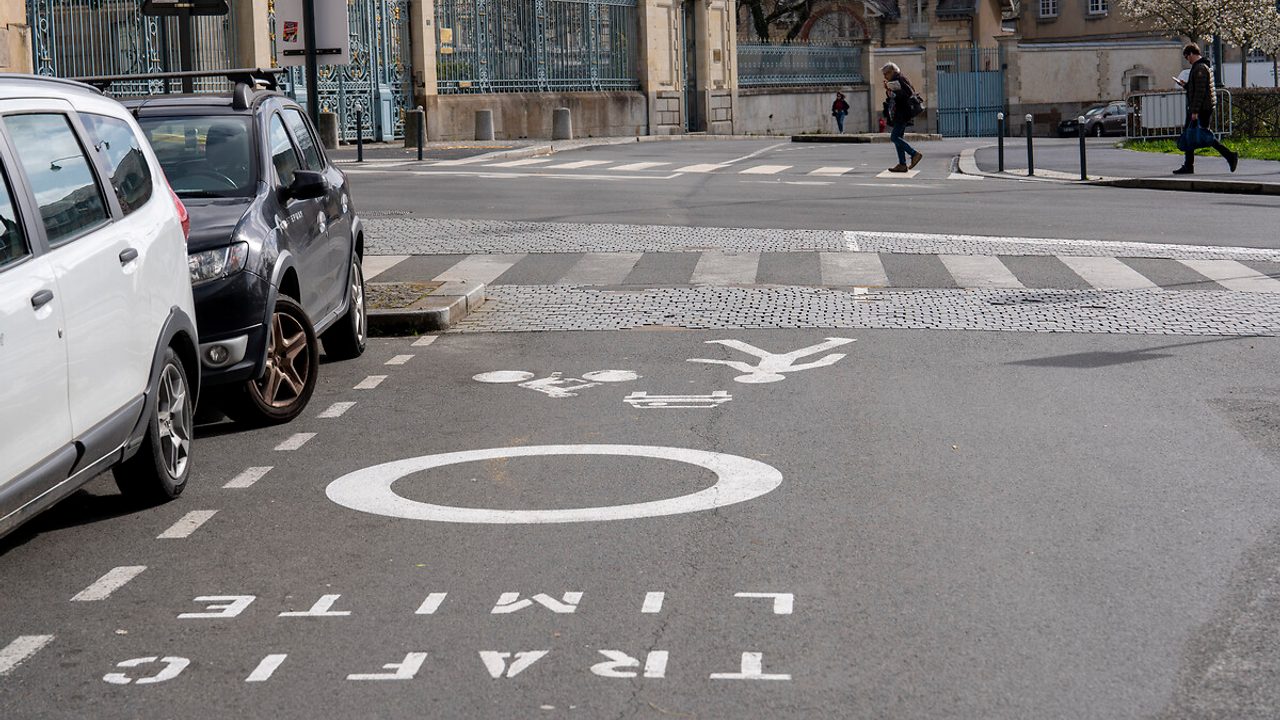 Photo d'une rue avec marquage "zone à trafic limité" sur la chaussée.