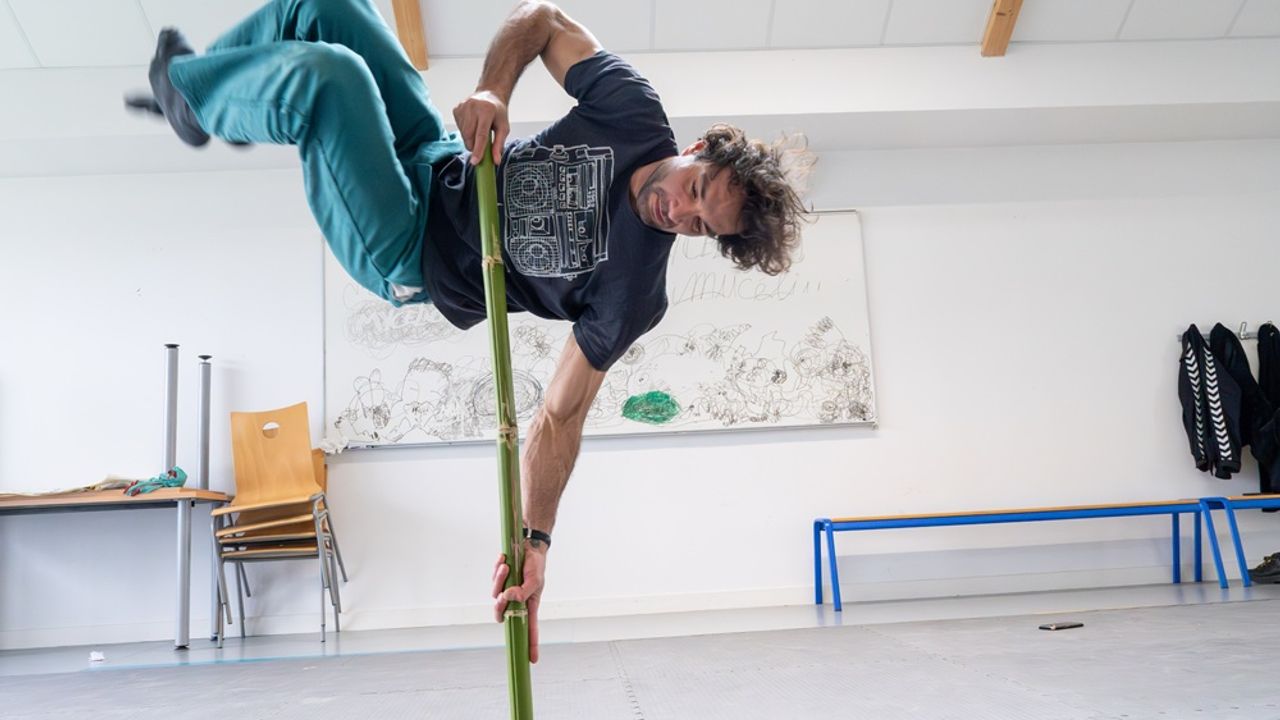 Anatole, du collectif Sous le manteau, en suspension sur un bambou