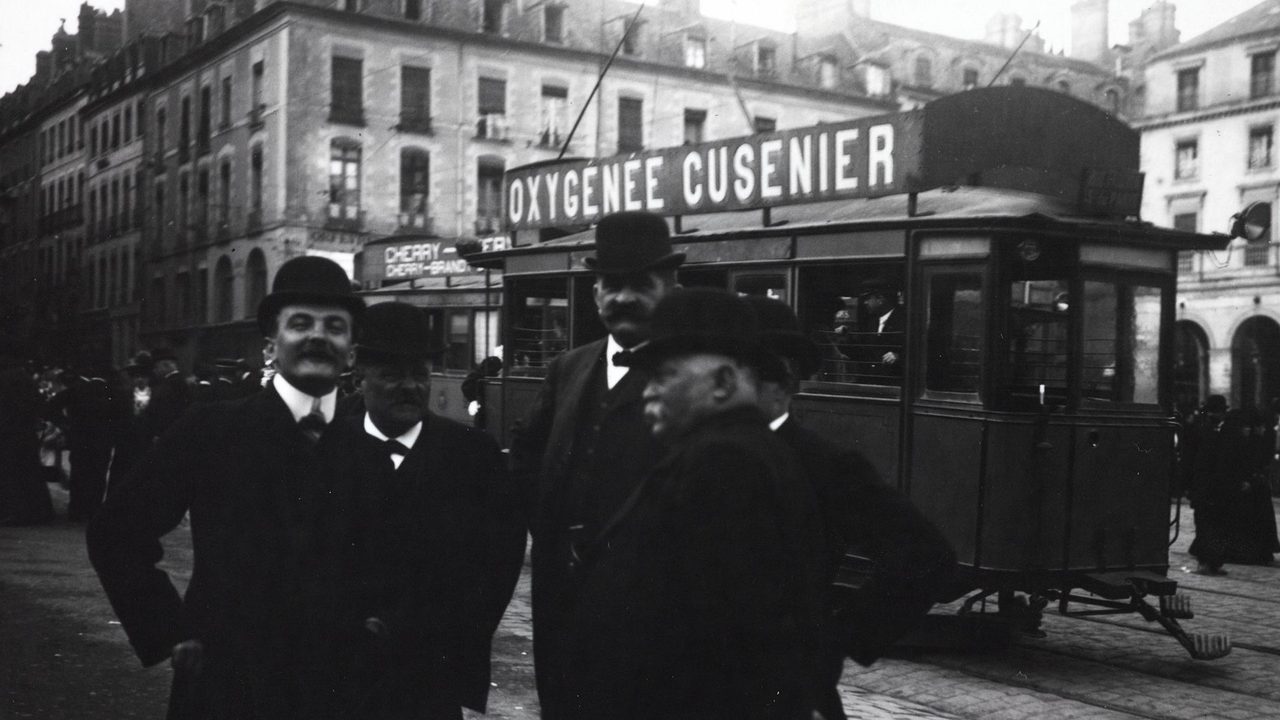 Jour d'élection, place de la mairie à Rennes en 1902, un groupe d'homme pose devant le tramway.