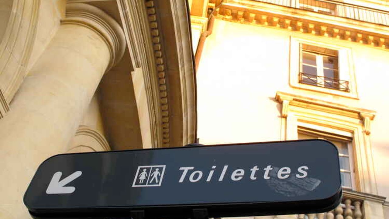 panneau affichant l'endroit où se trouvent les toilettes publiques