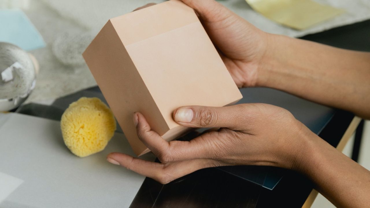 Personne tenant une petite boite en carton