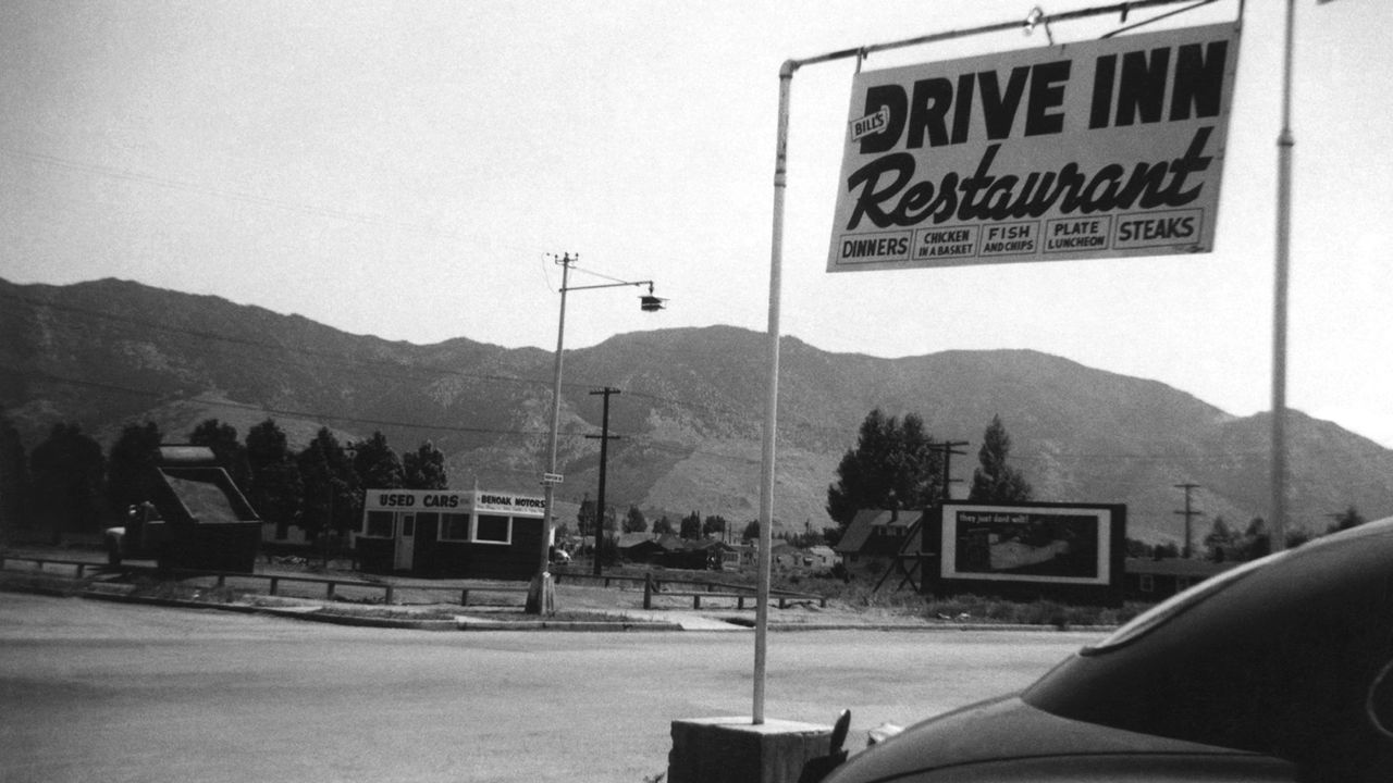 Une photographie en noir et blanc avec une enseigne Drive inn Restaurant