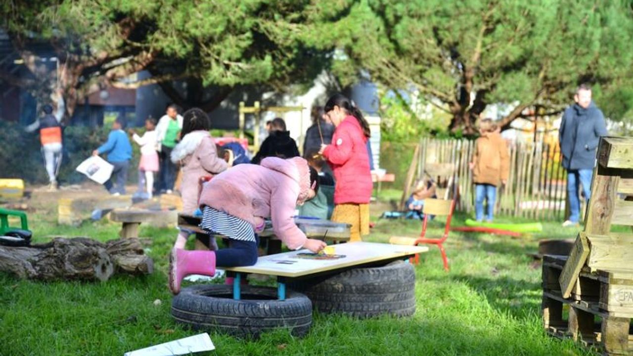 Des enfants jouent en botte et manteau d'hiver dans un parc public. Ils dessinent, jouent autour d'un feu et bricolent.
