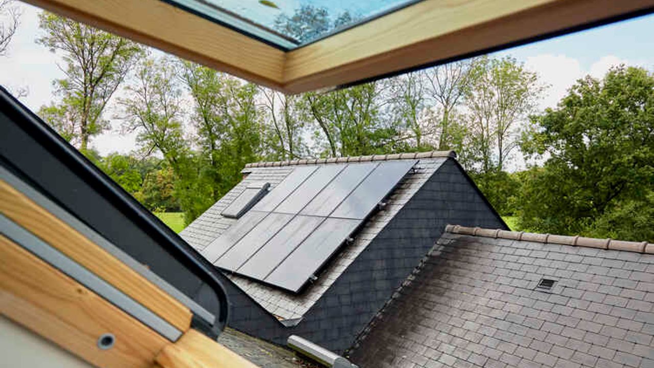 Vue sur des panneaux solaires installés sur un toit en ardoise.