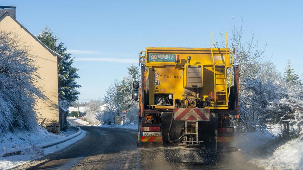 Une saleuse déneige une route