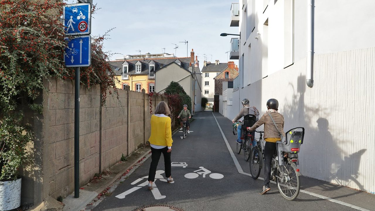 Groupe de piétons, cyclistes dans une rue de Rennes.