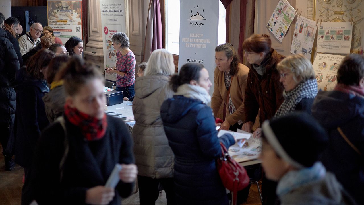 Le public profite des pauses pour déambuler au forum des associations. Ici, on peut apercevoir le stand du CoSE (Collectif Surexposition Ecrans), de Lève les yeux, et d'Enfant - Télé : Danger ?