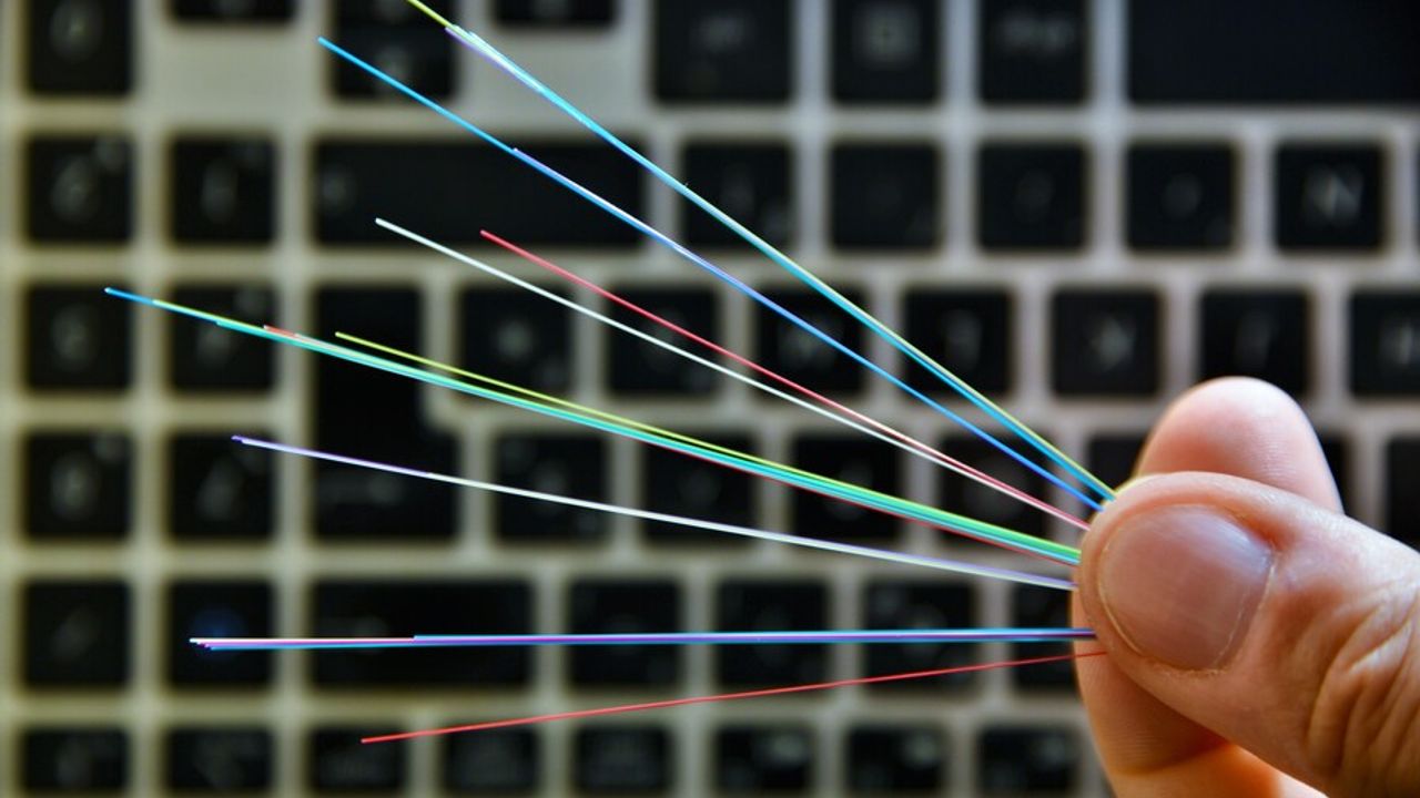 Fibre entre des mains avec un clavier d'ordinateur en arrière plan