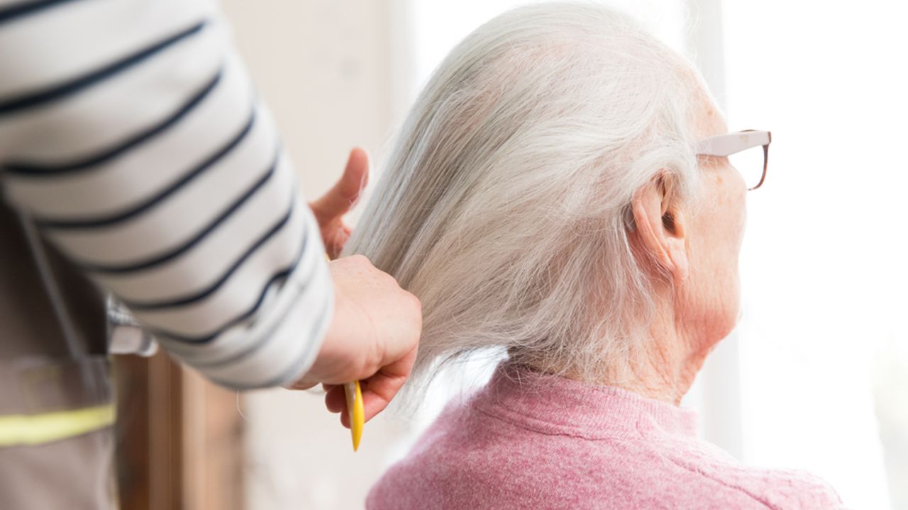 Une dame âgée se fait coiffer.