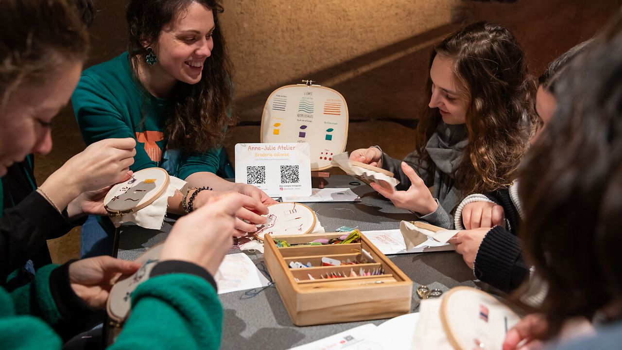 Groupe de personnes qui participent à un atelier de broderie.