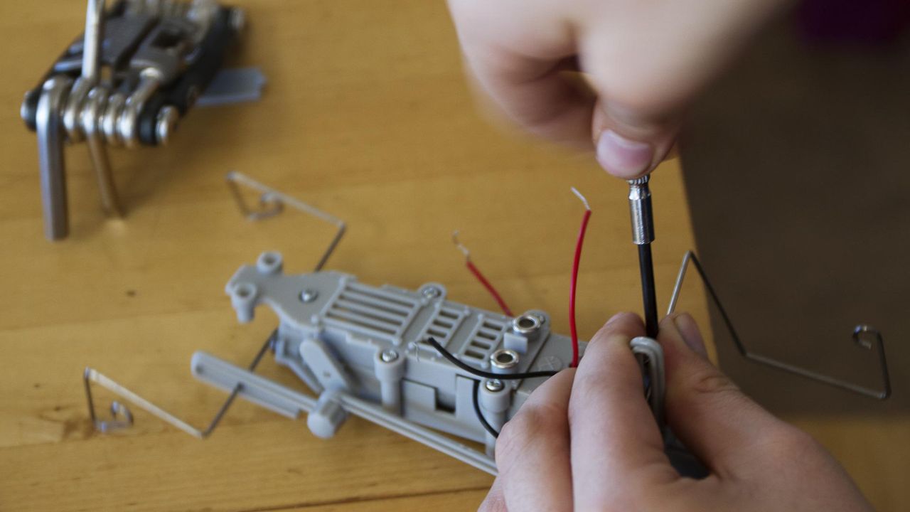 Mains d'enfants construisant un robot