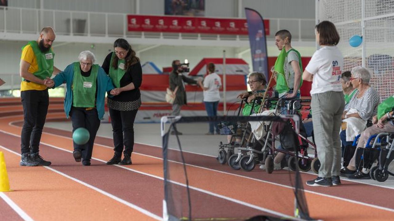 Une femme âgée joue au football