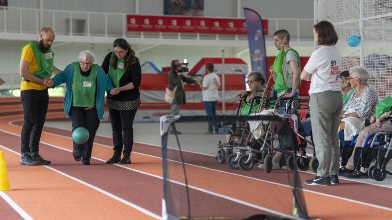 Une femme âgée joue au football