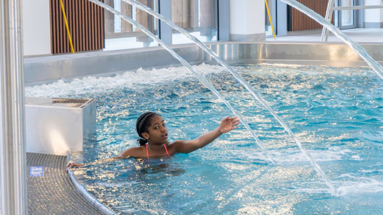 Une fillette touche l'eau d'un col de cygne