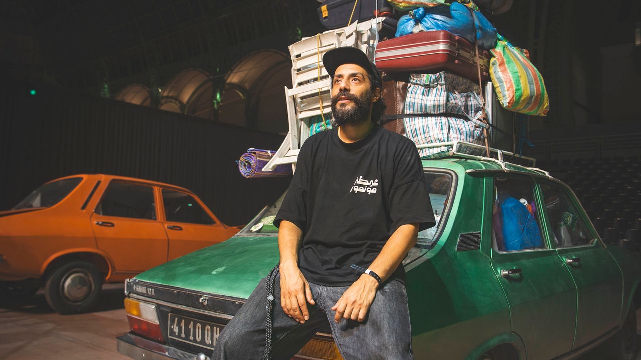 Le DJ marocain Retro Cassetta, assis sur le coffre arrière d'une Renault 12, avec plein de bagages sur le toit