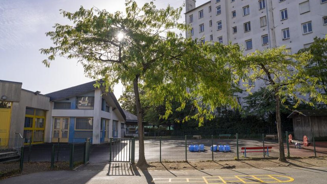 Vue extérieur de l'école avec l'entrée portail donnant sur les jeux de la cour de récréation.
