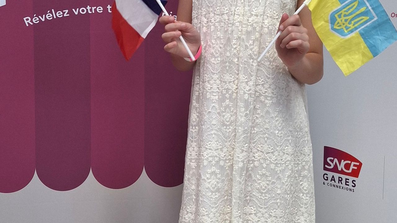 La jeune Nora Kostenko debout, tenant dans chaque main un drapeau français et ukrainien