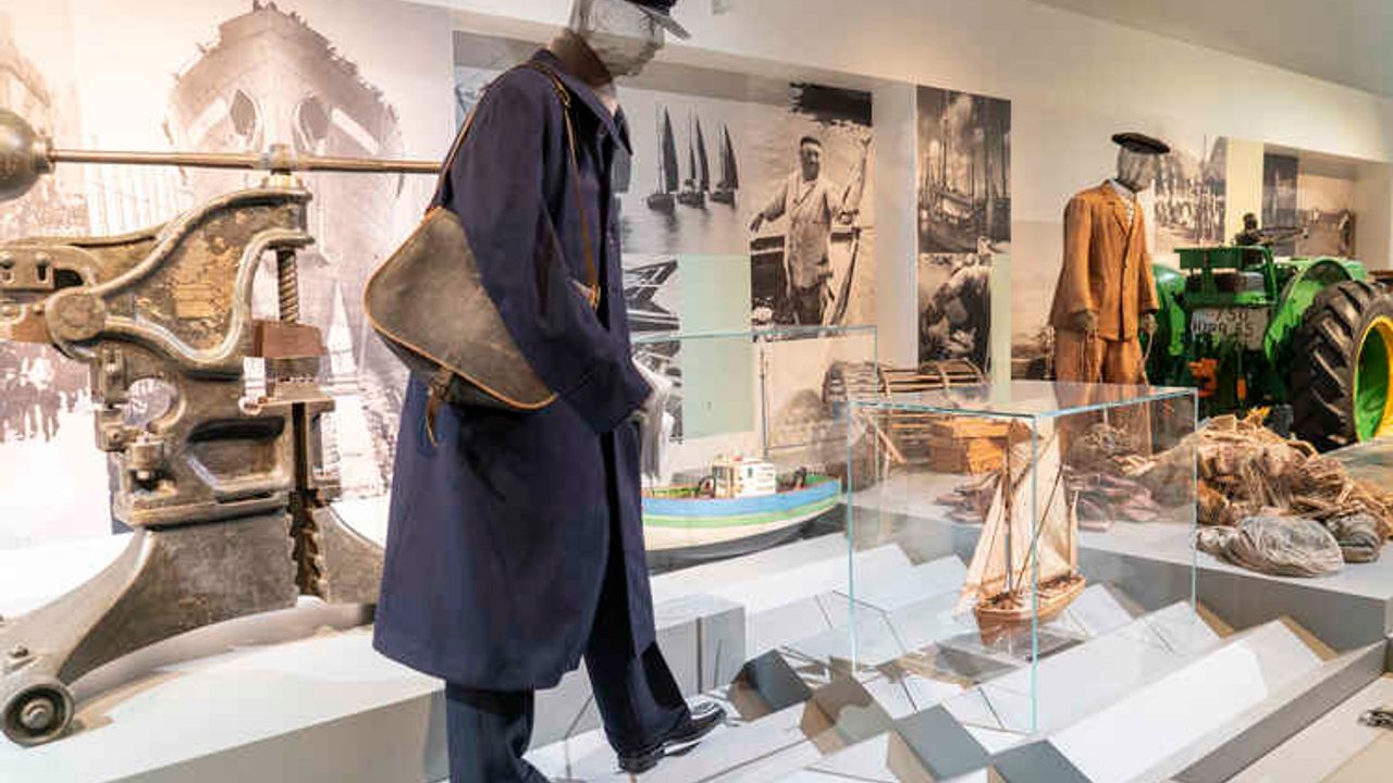 Au premier plan, un costume de facteur traditionnel, et sous vitrines différents objets bretons