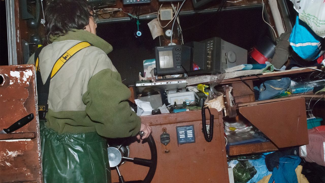 Femme pêcheuse au volant d'un bateau